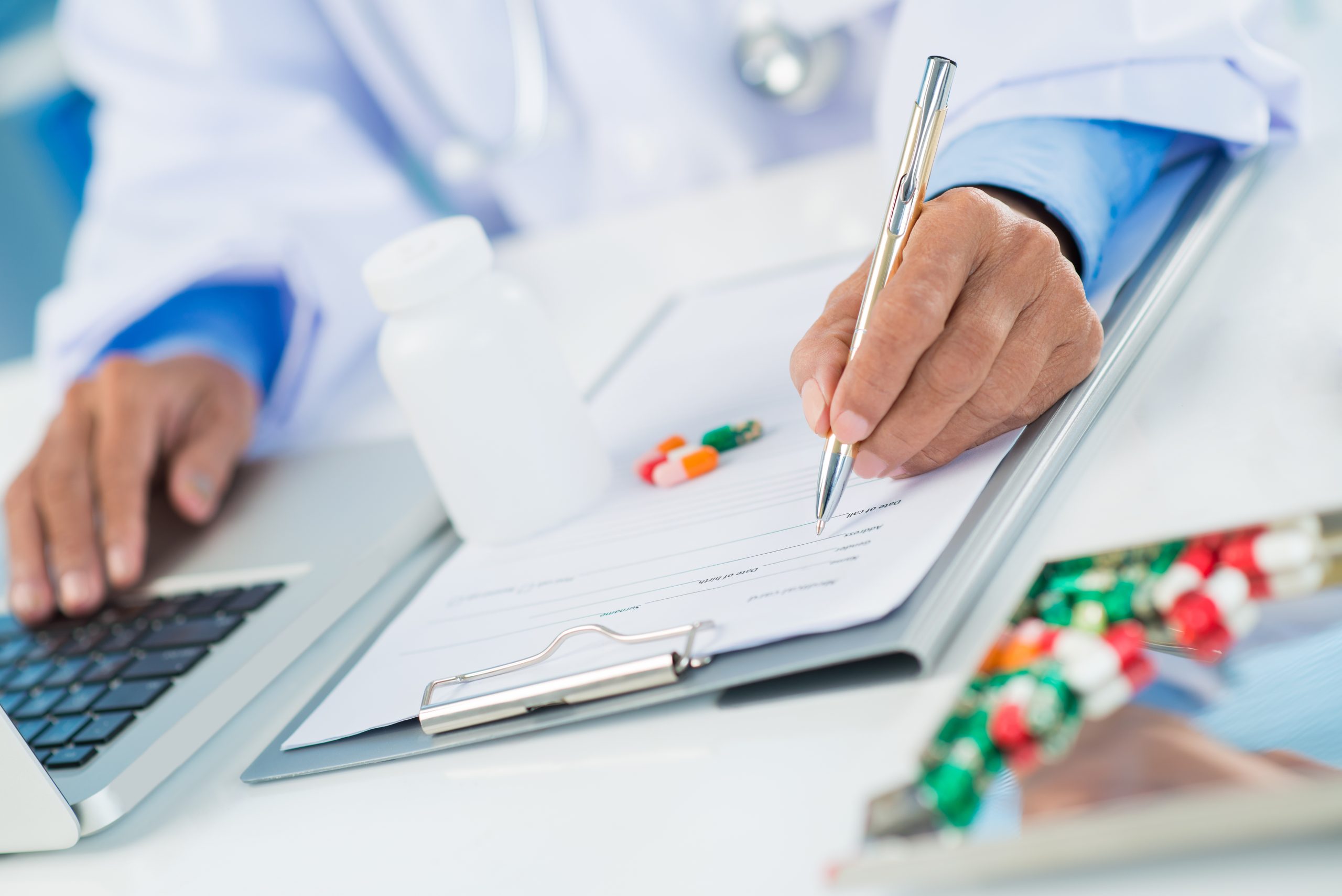 doctor-biomarker close up of doctor prescribing medicine